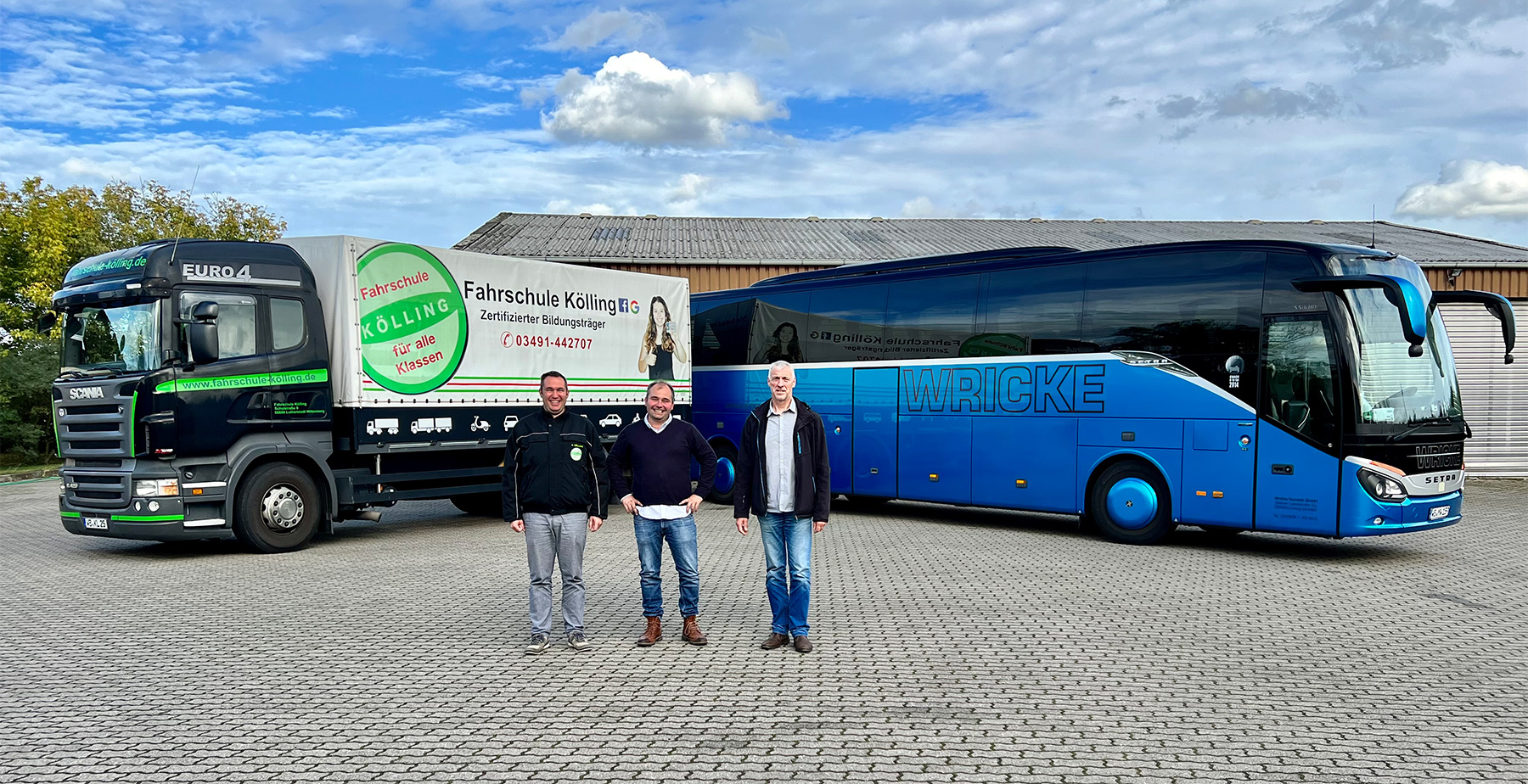 Drei Männer stehen vor einem LKW einer Fahrschule und einem Bus eines Touristik-Unternehmens