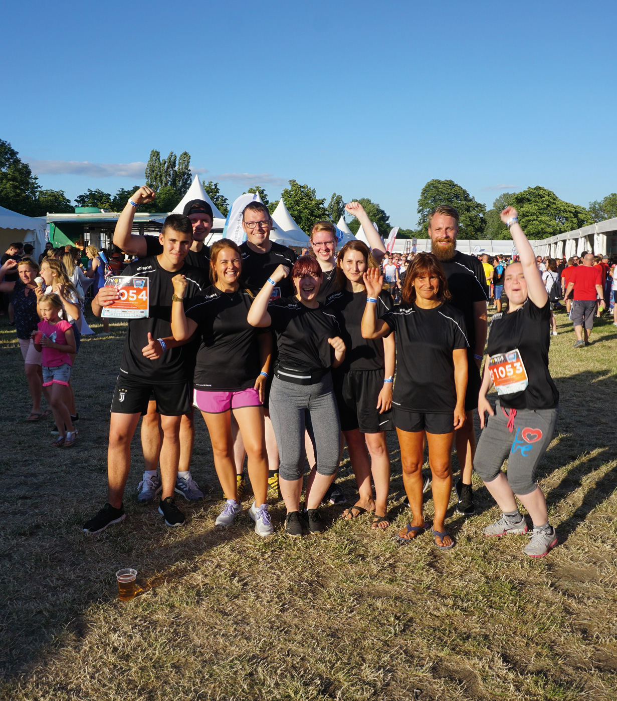 Zehn Mitarbeiterinnen und Mitarbeiter von Umland haben Sportkleidung an. Sie sind glücklich, lachen und schauen jubelnd in die Kamera. Es ist Sommer. Sie haben am Firmenlauf Magdeburg teilgenommen.