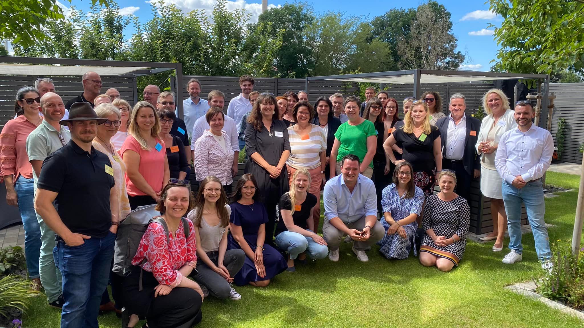 eine große Gruppe von Menschen steht auf einer Wiese