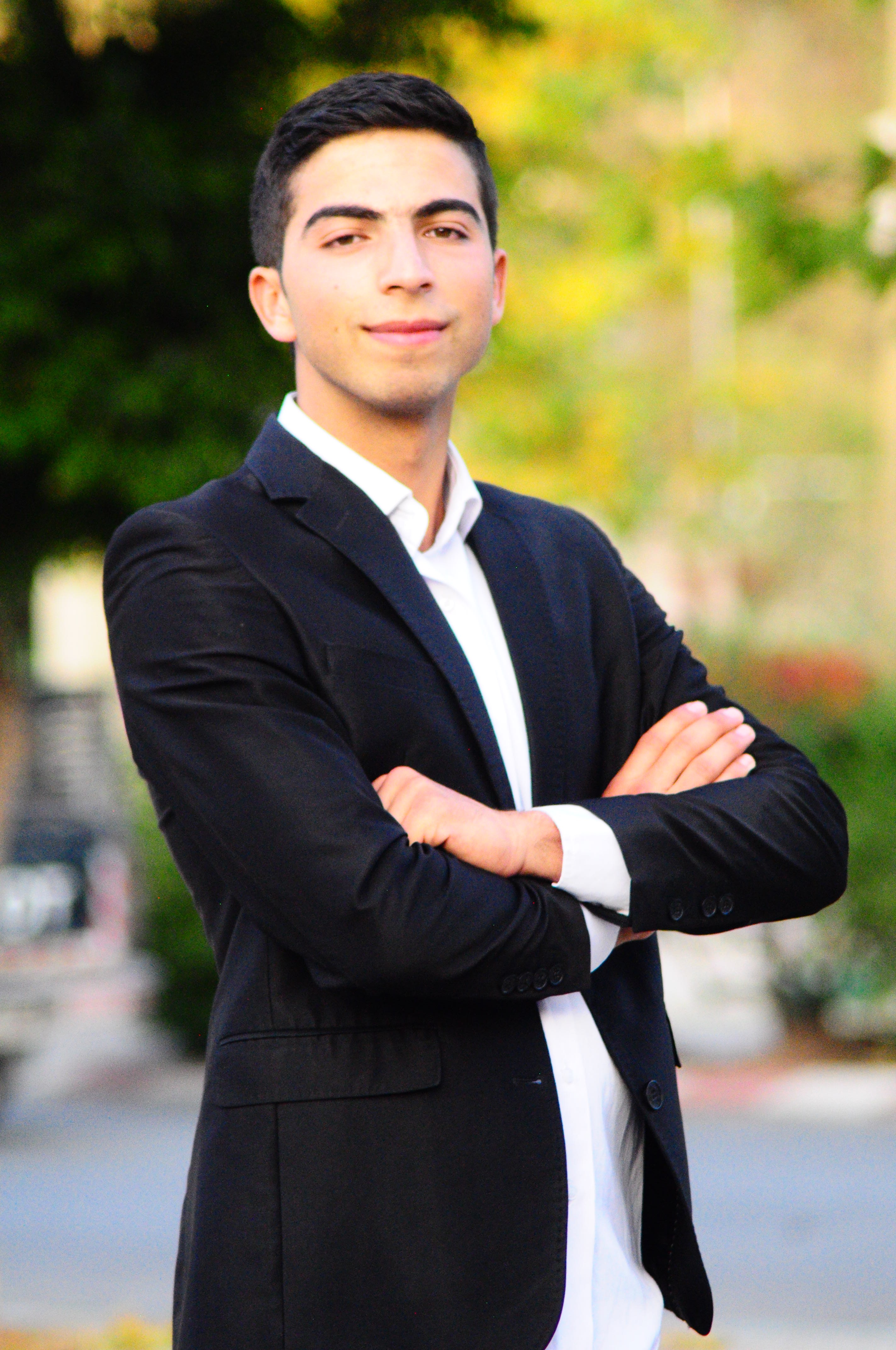 Ein junger Mann präsentiert sich mit souveränem Blick in Businesskleidung