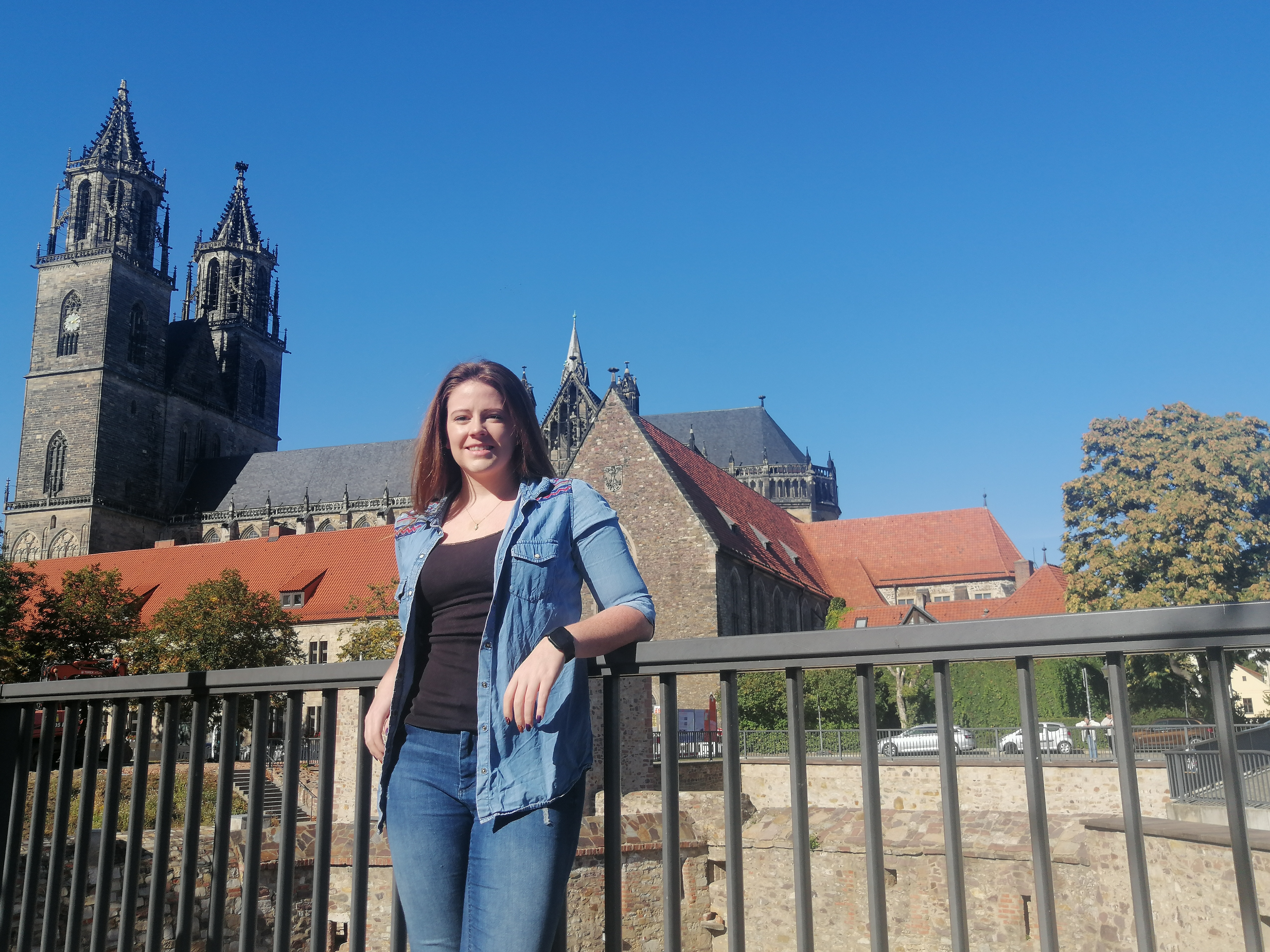 Rachel Neal steht an einem Zaun, im Hintergrund ist eine Kirche. (Foto: Rachel Neal)