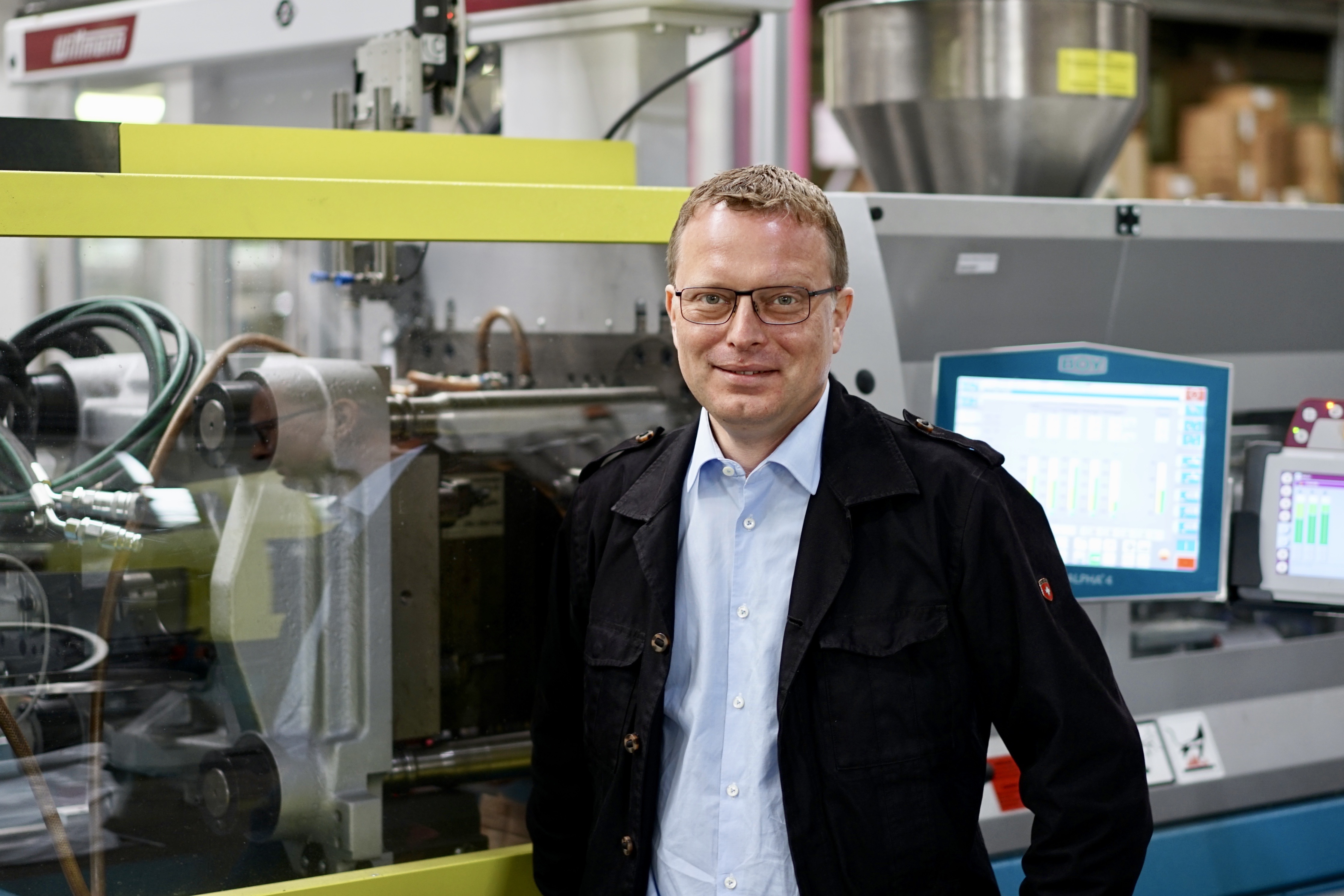 Ein Mann steht vor einer Maschine